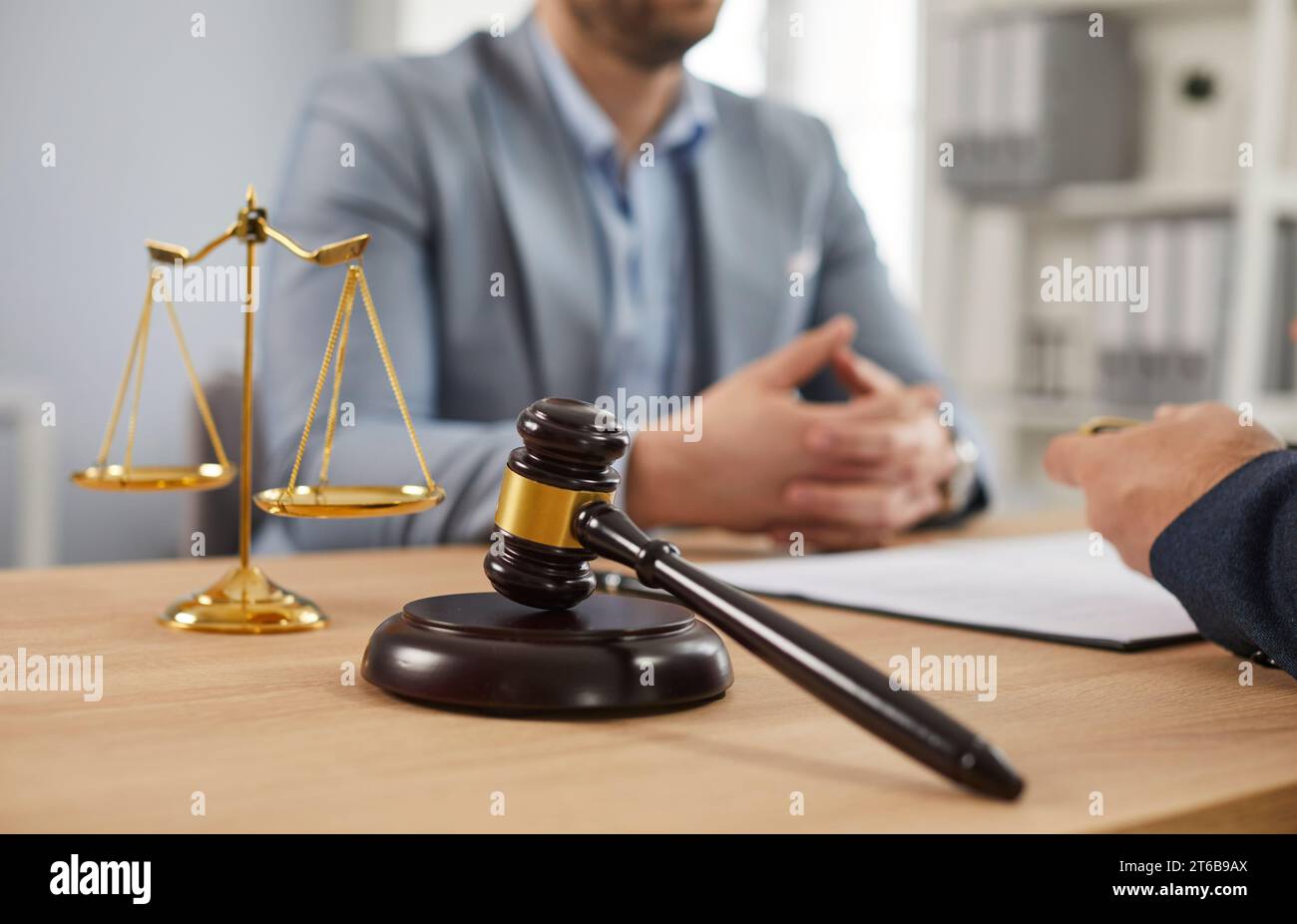 Nahaufnahme eines Fotos eines männlichen Anwalts, der an seinem Arbeitsplatz im Büro auf einem Holztisch arbeitet. Stockfoto
