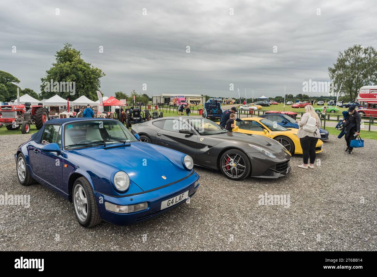 Tarporley, Cheshire, England, 30. Juli 2023. Blaues Porsche 911 Cabriolet und grauer Ferrari F12 bei einem Car Meet, Illustration für den Lifestyle im Automobil. Stockfoto