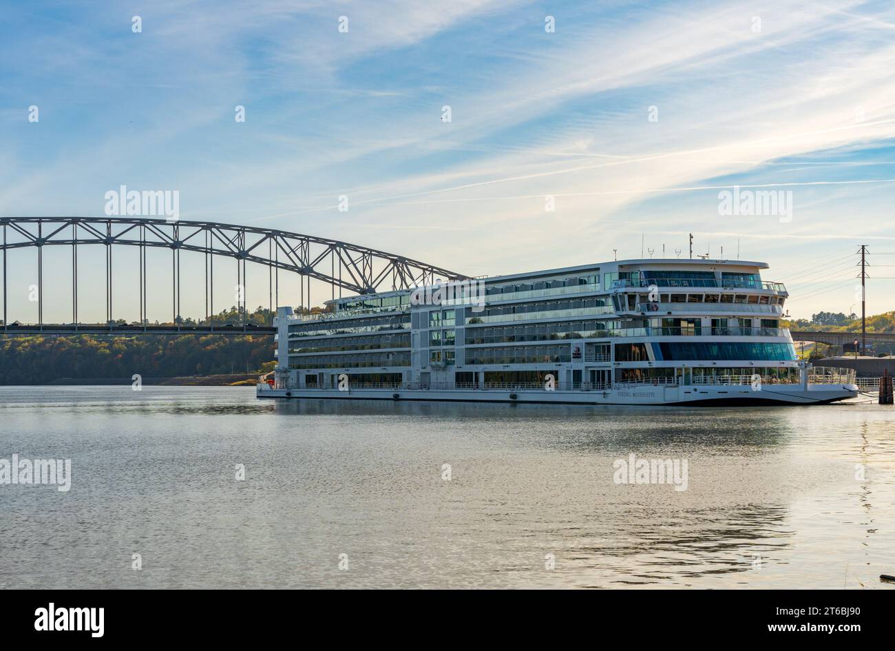 Dubuque, IA - 17. Oktober 2023: Viking Mississippi River Cruise Boat an einer modernen Straßenbrücke auf dem Mississippi River in Iowa angedockt Stockfoto