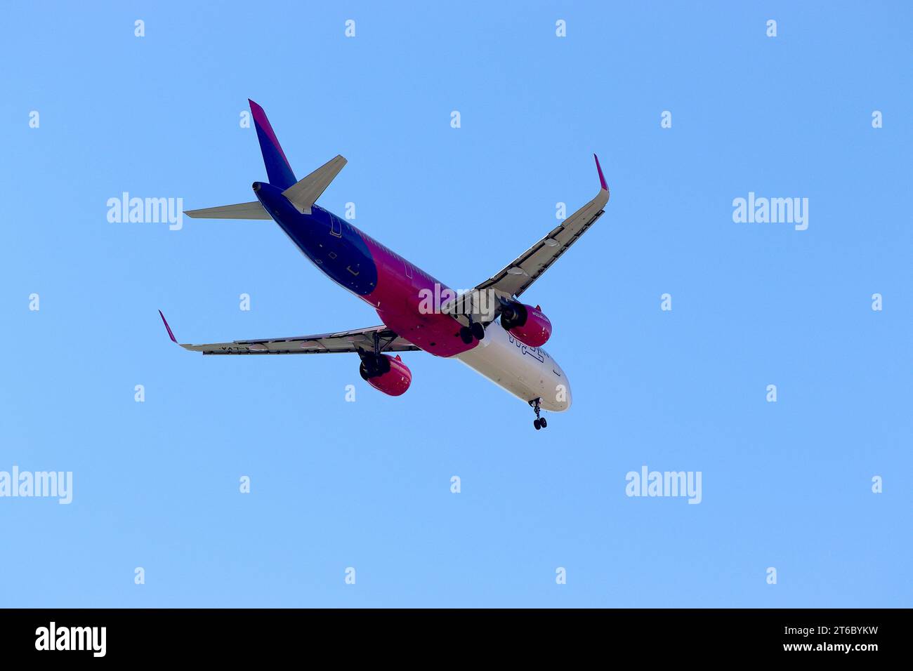 Der Airbus A321neo mit der Registrierung HA-LVA von Wizz Air steht bei der Ankunft am Flughafen Cagliary Elmas über dem P&O-Kreuzfahrtschiff Aurora an. Stockfoto