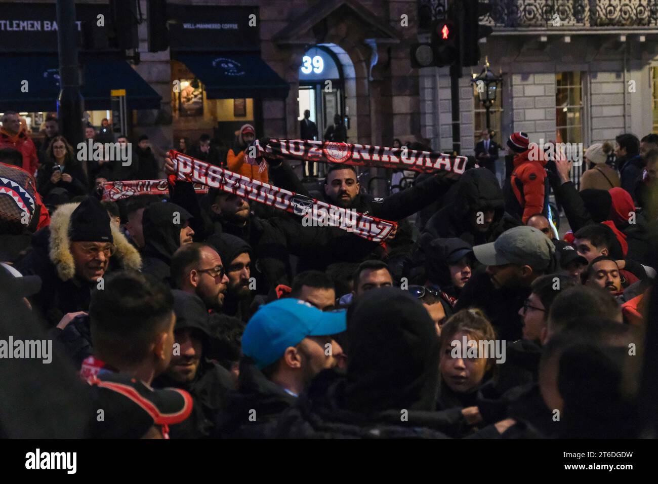 London, Großbritannien. November 2023. Olympiacos Fußballfans treffen sich in Piccadilly vor dem Spiel ihrer Mannschaft in der Europa League gegen West Ham im London Stadium. Quelle: Eleventh Photography/Alamy Live News Stockfoto