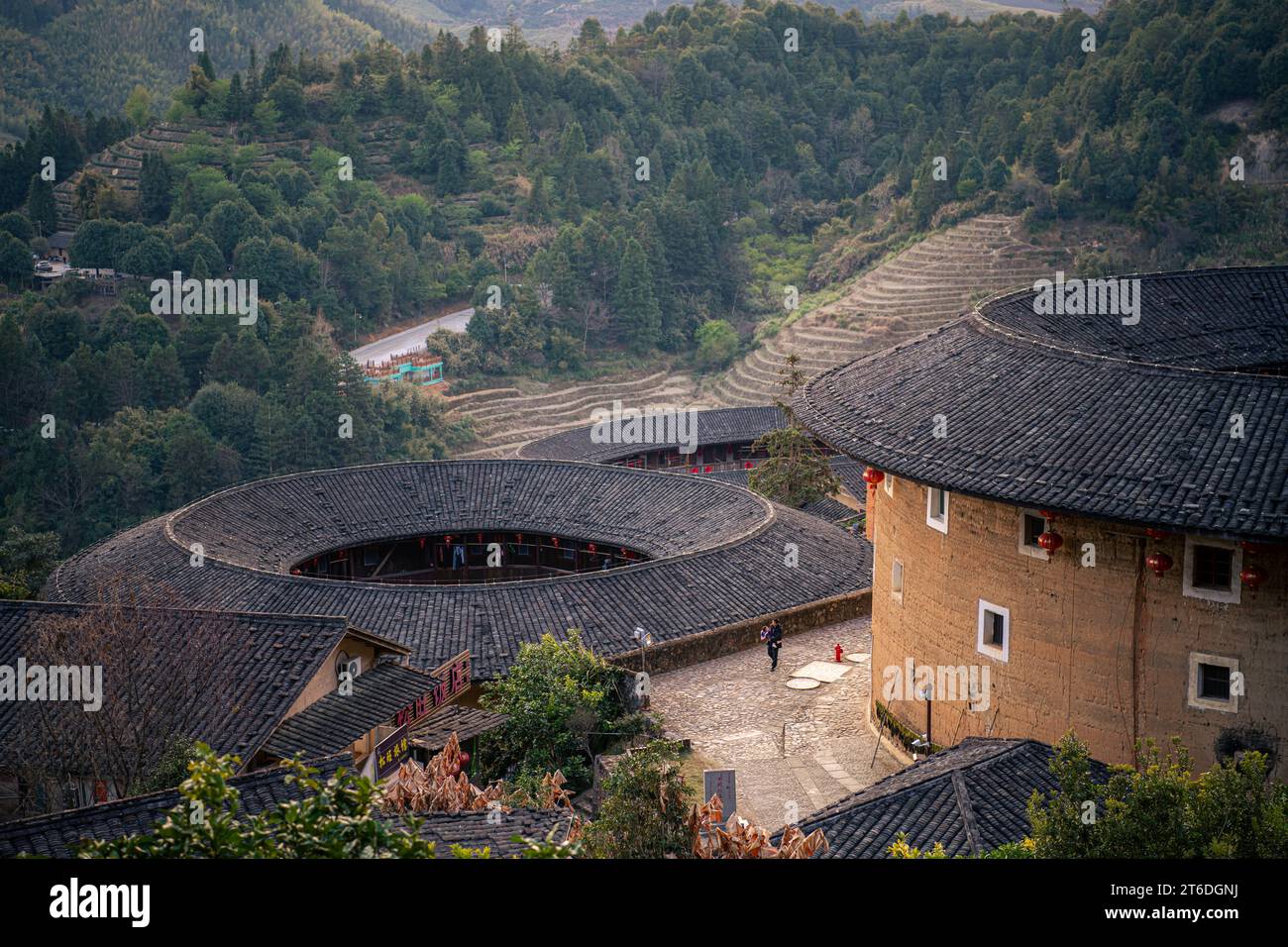 Chinesisches Fujian Tulou und die umliegende Landschaft während des Sonnenuntergangs. Es wurde zum UNESCO-Weltkulturerbe erklärt. Ein berühmtes historisches Relikt. Stockfoto Chinesisches Fujian Tulou und die umliegende Landschaft während des Sonnenuntergangs. Es wurde zum UNESCO-Weltkulturerbe erklärt. Ein berühmtes historisches Relikt. Stockfoto