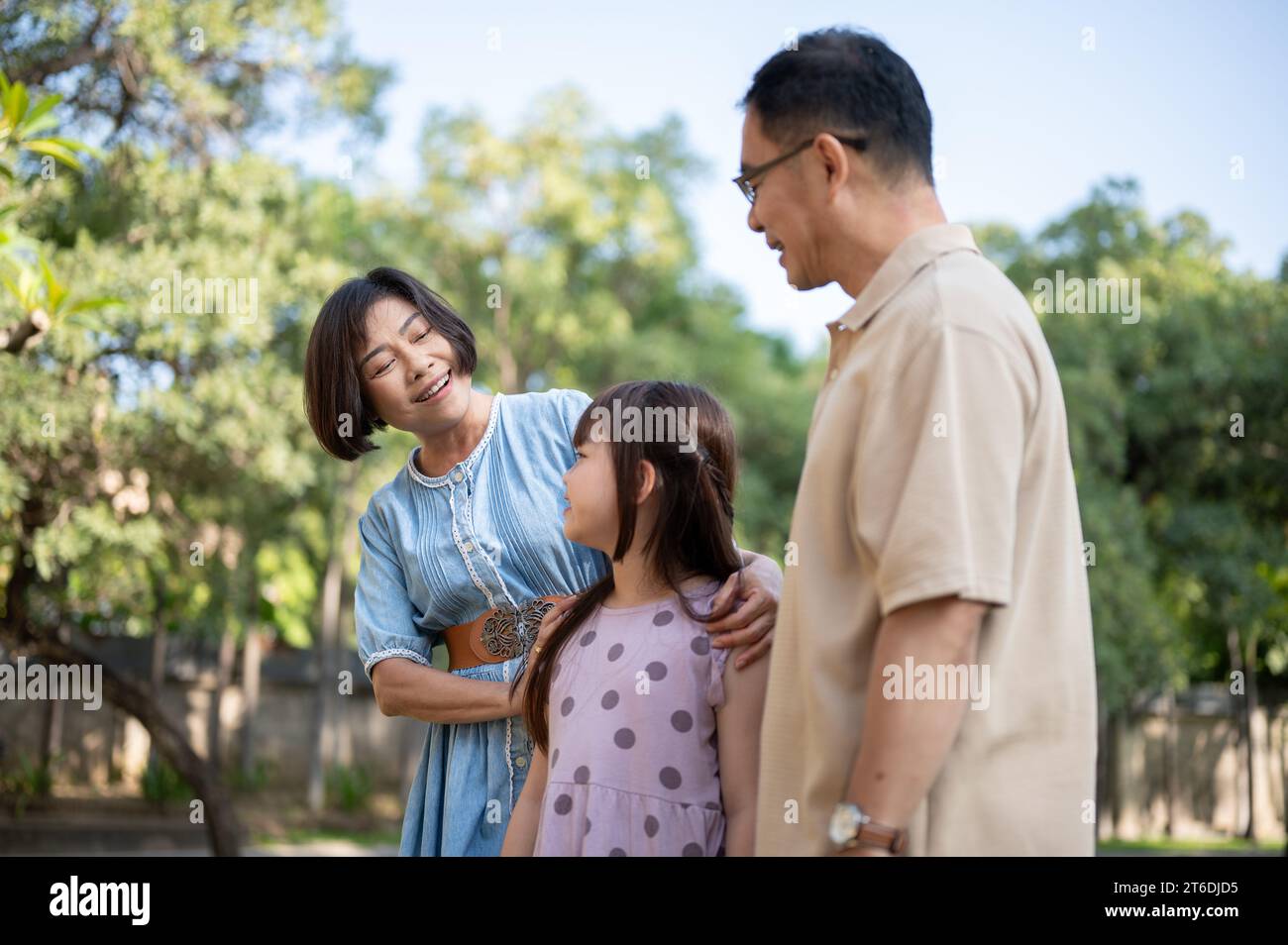 Nette und glückliche asiatische Großeltern haben Spaß mit ihrer Enkelin und schlendern an einem hellen Tag gemeinsam durch den öffentlichen Park. Glückliche Familie, fa Stockfoto