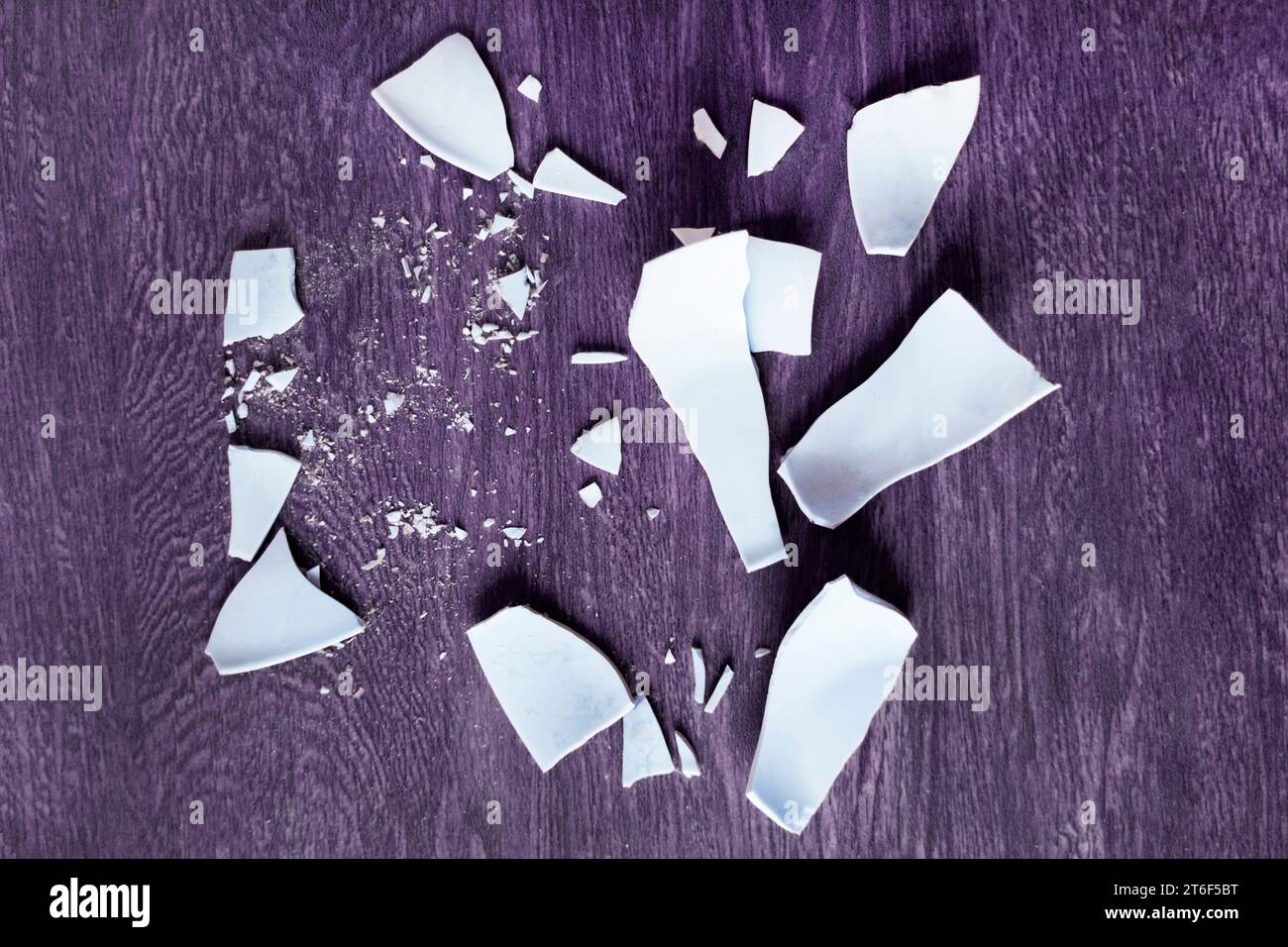 Scherben auf dem Hintergrund. Splitter, Fragmente eines Geschirrs auf dem Boden. Trümmer und Stücke eines gebrochenen Teller, Schale Stockfoto