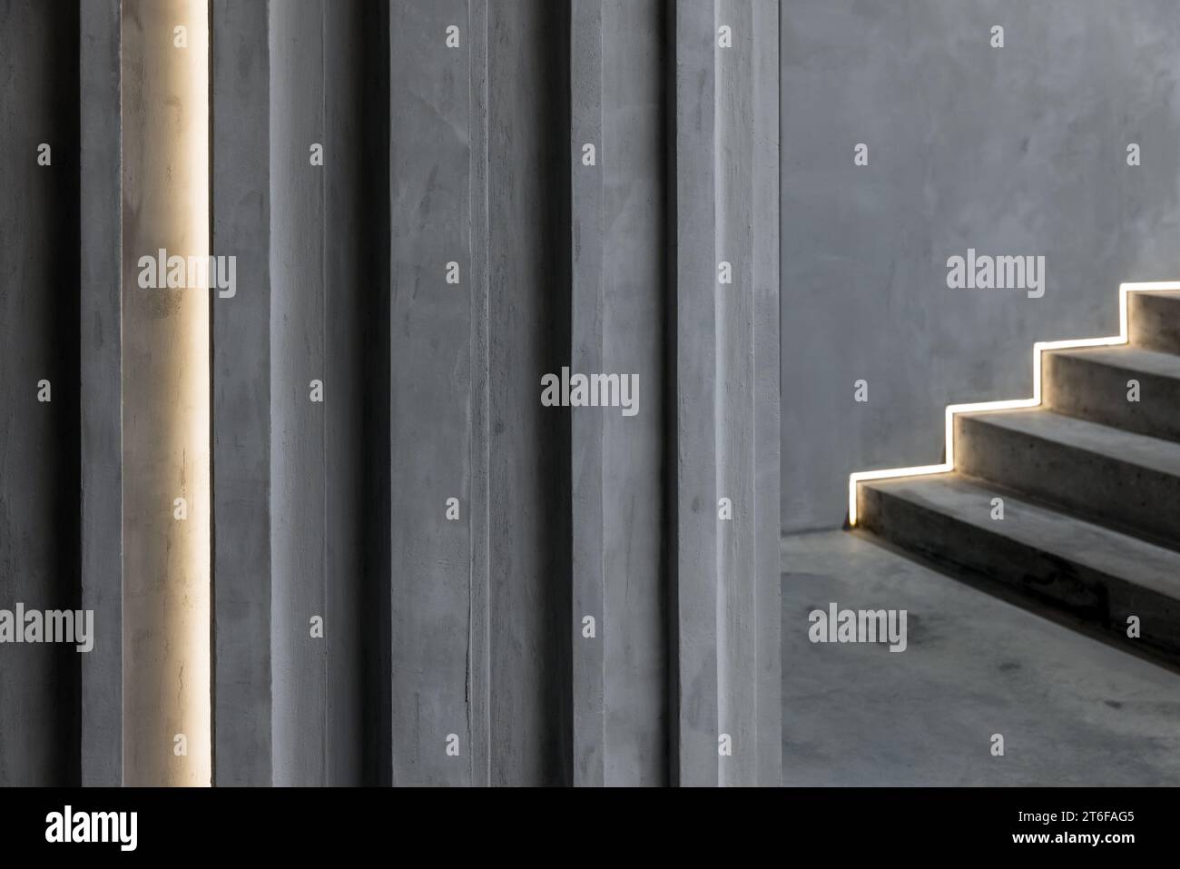 Abstrakter dunkler Betonraum-Innenhintergrund. Wand und Treppe mit LED-Lichtlinien Stockfoto