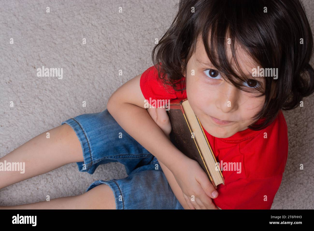 Kleiner Junge mit Buchhand als Bildungs- und Studienkonzept Stockfoto