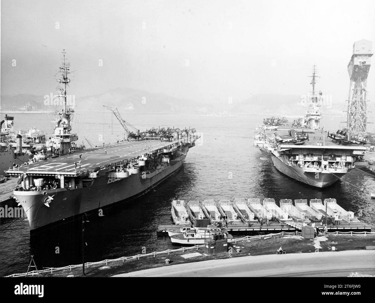 USS Sicily (CVE-118) und USS Yorktown (CVA-10) auf der Yokosuka Naval Base, Japan, um Februar 1954 Stockfoto