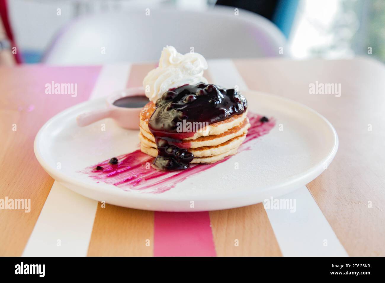 Himbeerpfannkuchen mit Schlagsahne, serviert in einem Café. Stockfoto