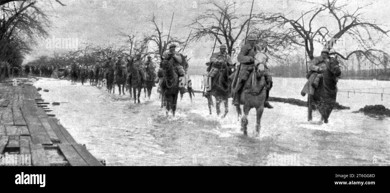 "L'Arret du repli allemand; Aux abords de la Fere, Apres le 21 mars: un Detachement de cavalerie sur une Route envahie par l'inondation que l'ennemi, afin de proteger ses derrieres, a provoquee au moyen de barrages", 1917. Aus L'Album de la Guerre 1914-1919, Band 1 [L'Illustration, Paris, 1924]. Stockfoto