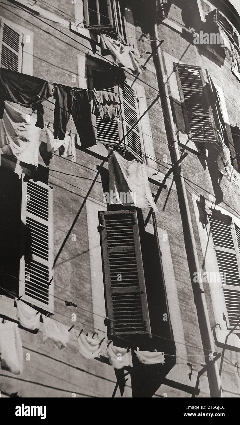Frankreich 1939 - Eine typische Szene, in der Tageswäsche an Fenstern mit Fensterschlitzen hängt - Frankreich 1939 - UN typique; scène le jour du Lavage du linge accroché aux fenêtres à persiennes Stockfoto