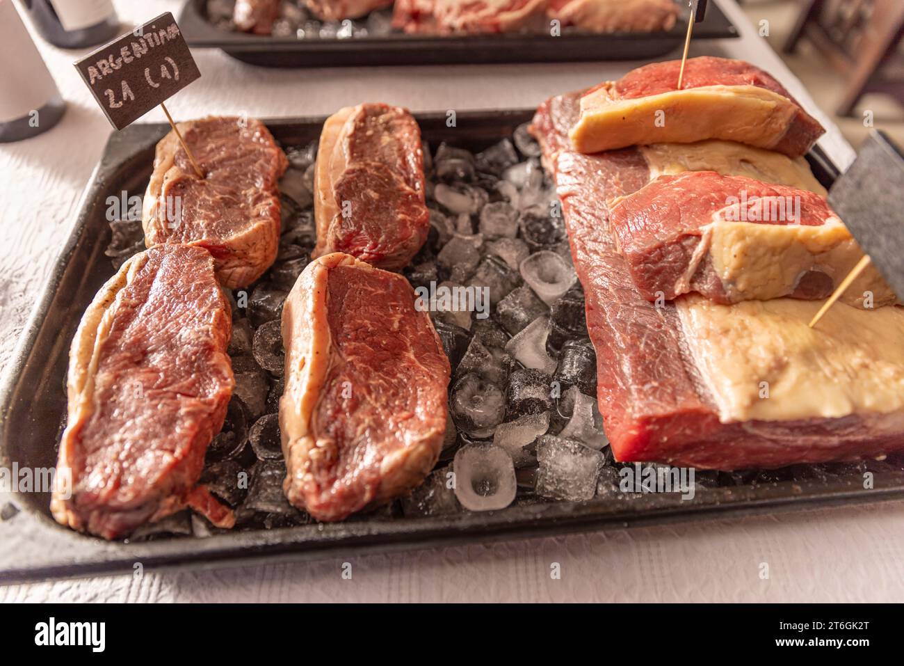 Tablett mit rohem Fleisch, in große Stücke geschnitten und auf ein Eisbett gelegt Stockfoto