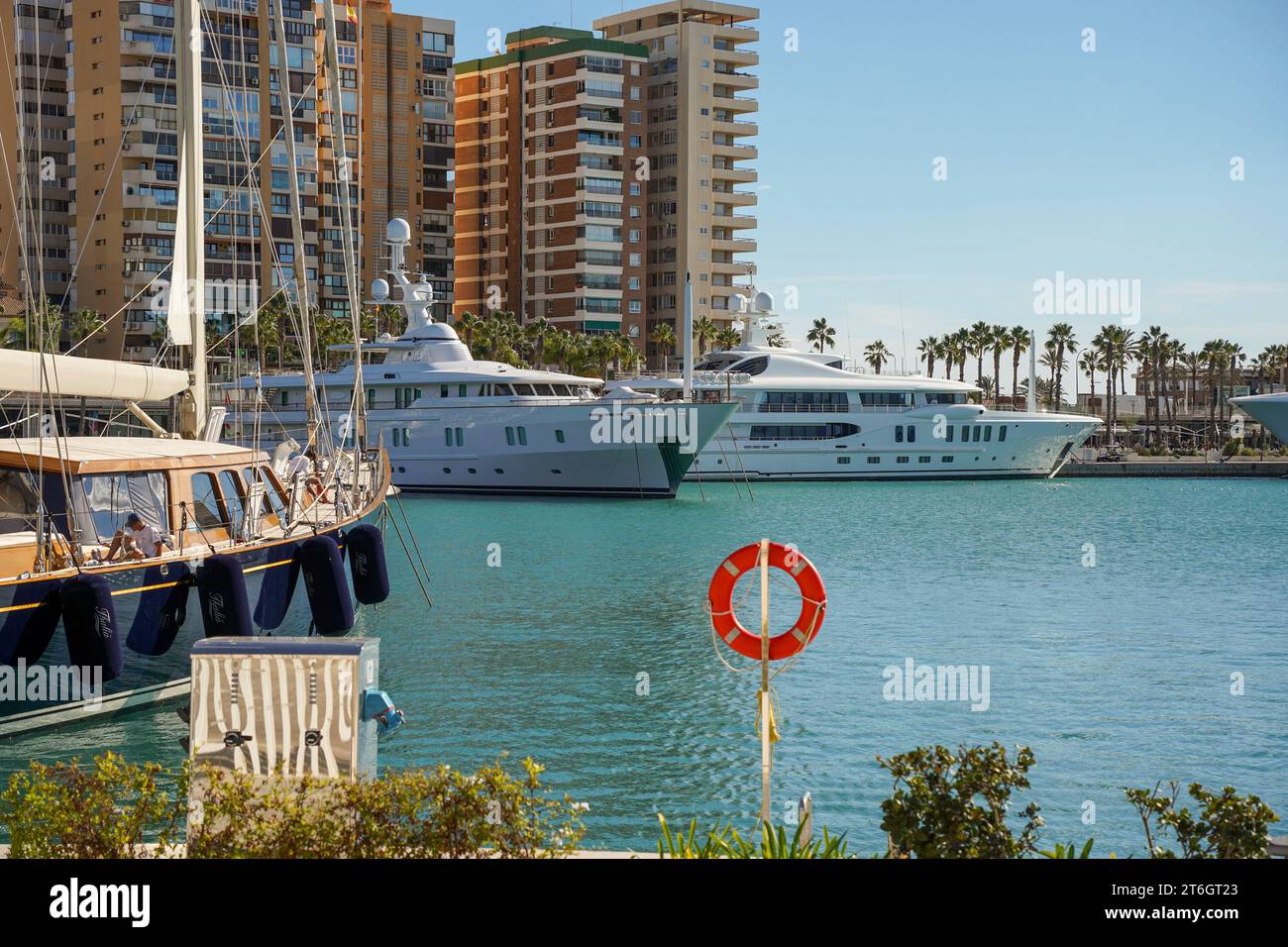 Superyachten oder Megayachten und La Malagueta Viertel im Hafen von Malaga, Costa del Sol, Andalusien, Spanien. Stockfoto