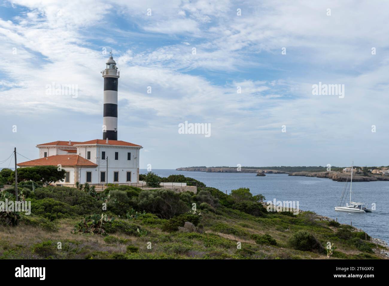 Allgemeiner Blick auf den Leuchtturm der mallorquinischen Stadt Portocolom bei Sonnenaufgang an einem Herbsttag. Spanien Stockfoto