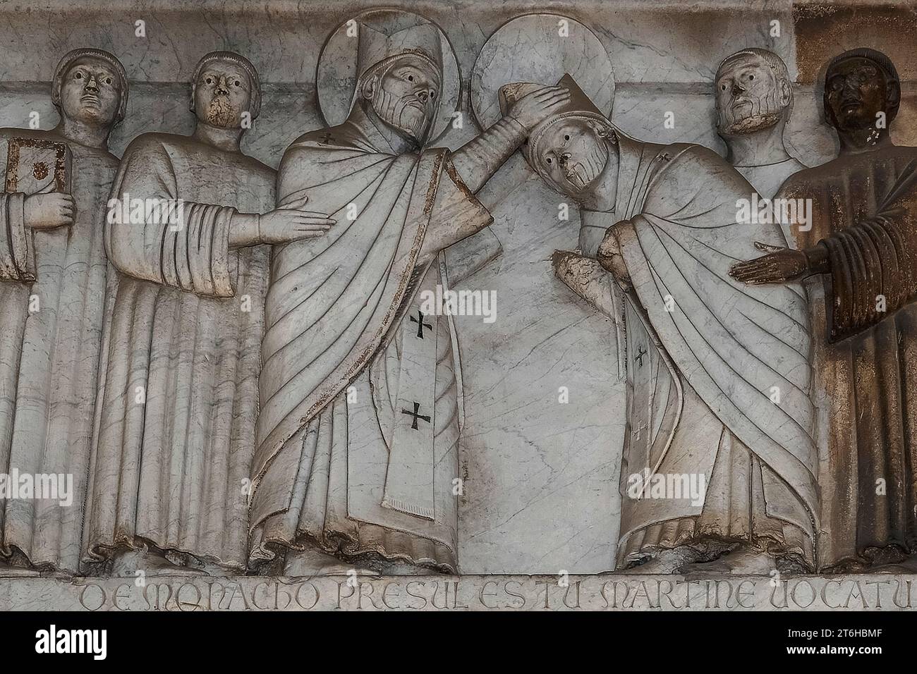 Szene aus „Storie di San Martino“, einer Reihe romanischer Reliefs aus dem 13. Jahrhundert an der Fassade des Duomo di San Martino, Lucca, Toskana, Italien. Die Reliefs, die Szenen aus dem Leben des heiligen Martin von Tours darstellen, können das Werk des lombardischen Bildhauers Guido oder Guidetto di Bonagiunta Bigarelli sein, bekannt als Guido da Como (1220–ca. 1257). Stockfoto