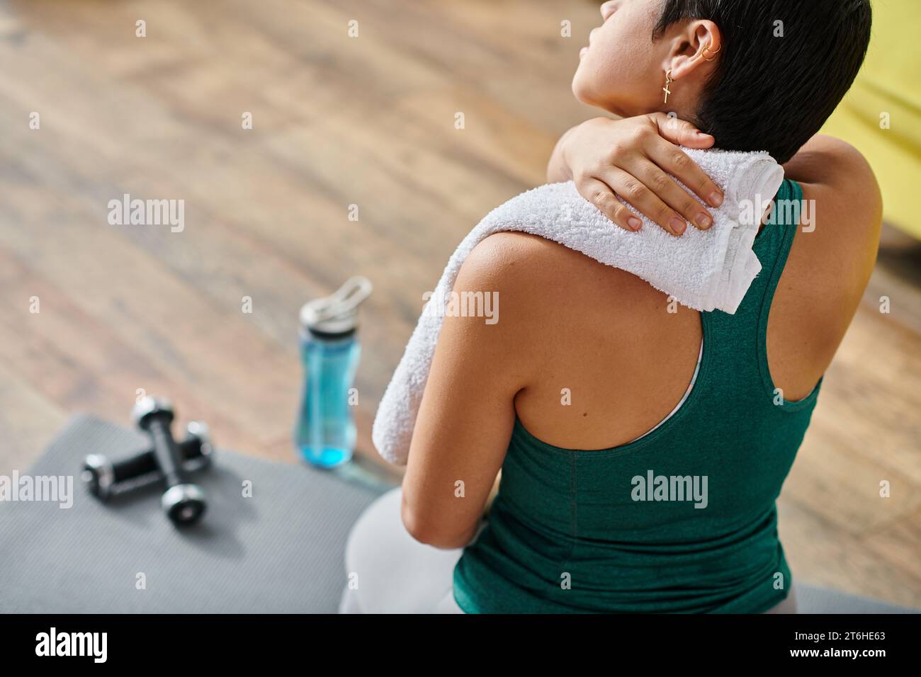 Zugeschnittene Ansicht einer jungen kurzhaarigen Frau in Sportbekleidung mit Handtuch nach Training, Fitness Stockfoto