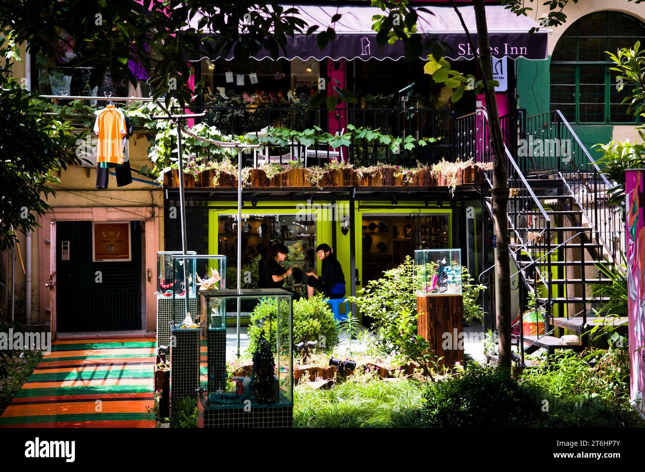 China Shanghai, Eingang einer Modeboutique in Xinle Lu, französische Konzession, zwei chinesische Frauen sitzen im Garten Stockfoto