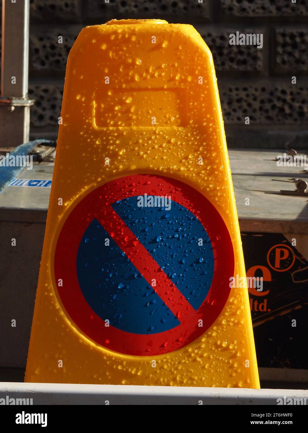 Gelber „kein Warten“-Verkehrskegel mit schwachem Sonnenlicht, das auf Regentropfen spielt. Bad, Somerset. November 2023. Stockfoto