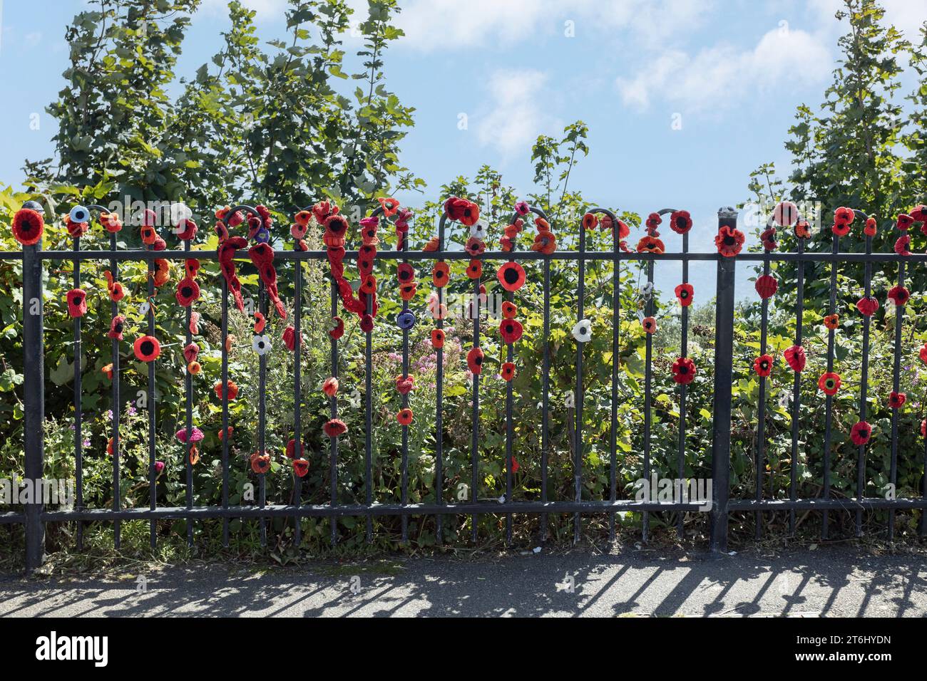 Handgestrickter roter Mohn, der an den Geländern neben dem Step Short Memorial für Soldaten befestigt ist, die im Ersten Weltkrieg starben Stockfoto