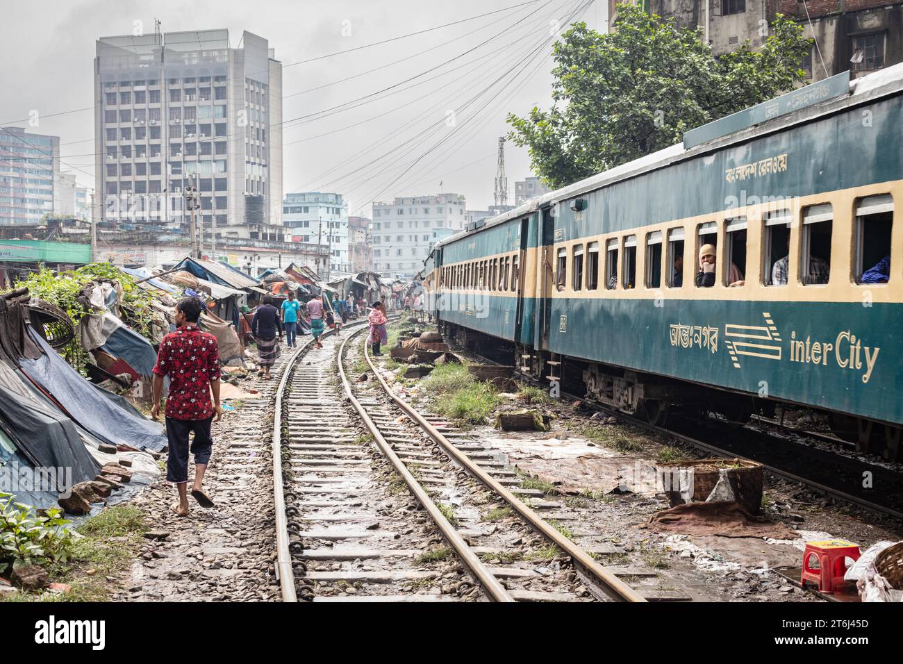 Personenzug, der durch eine Slumsiedlung fährt, Tejgaon Slum Area, Dhaka, Bangladesch Stockfoto