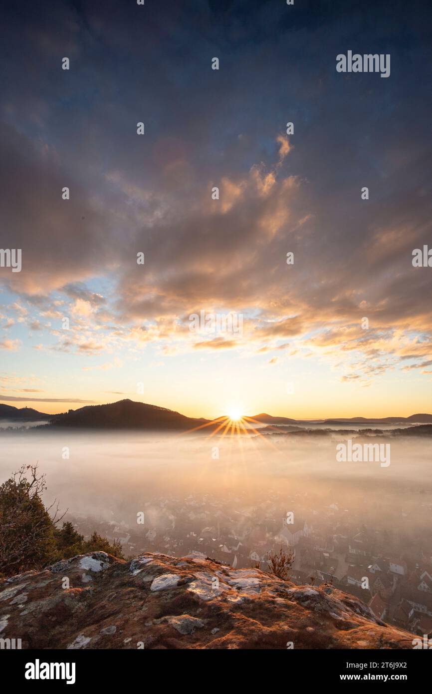 Mystischer Sonnenaufgang am Wachtfelsen. Faszinierende Landschaft zwischen Nebel und Wolken in der Nähe von Wernersberg, Pfälzerwald, Deutschland. Stockfoto