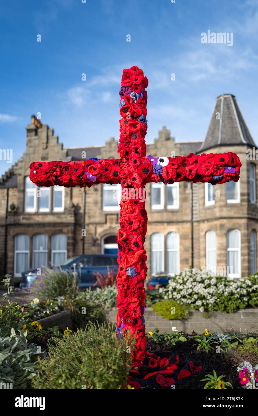 Cluny Square, Buckie, Moray, Großbritannien. November 2023. Dies ist die Erinnerung in dieser belebten Stadt, mit Rotem Mohn, Soldiers Hut und Stiefeln und einem großen Kreuz mit Mohn, um Soldaten, Pferden, Hunden und anderen Tieren zu erinnern, die in den Kriegen verloren gegangen sind. Quelle: JASPERIMAGE/Alamy Live News Stockfoto