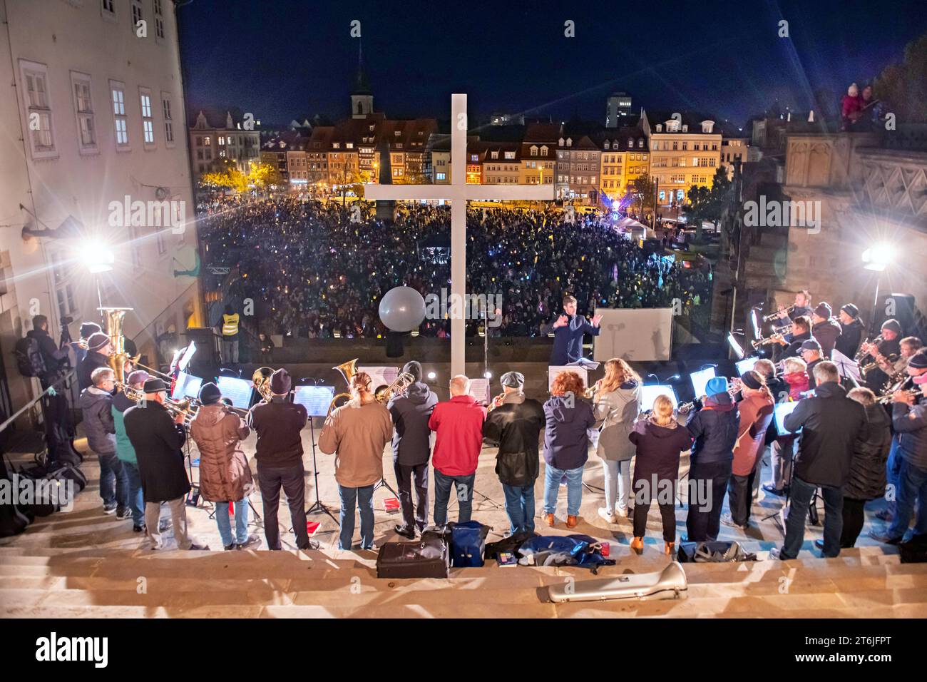 Musiker leiten mit ihren Posaunen den Gottesdienst ein und tausende Menschen schwenken ihr Laternen waehrend einer Martini-Feier am 10.11.2023 in Erfurt. Seit Jahrzehnten vereint die oekumenische Martinsfeier tausende Menschen auf dem Erfurter Domplatz. 1972 zum ersten Mal. Sie gilt sowohl dem Stadtpatron, dem heiligen Martin von Tours als auch Martin Luther, der eng mit Erfurt verbunden ist. Musiker stellen den Gottesdienst mit ihren Trompeten vor und Tausende von Menschen schwenken ihre Laternen während einer Martini-Feier am 10. November 2023 in Erfurt. Jahrzehntelang ist das ökumenische St. Martin s cele Stockfoto