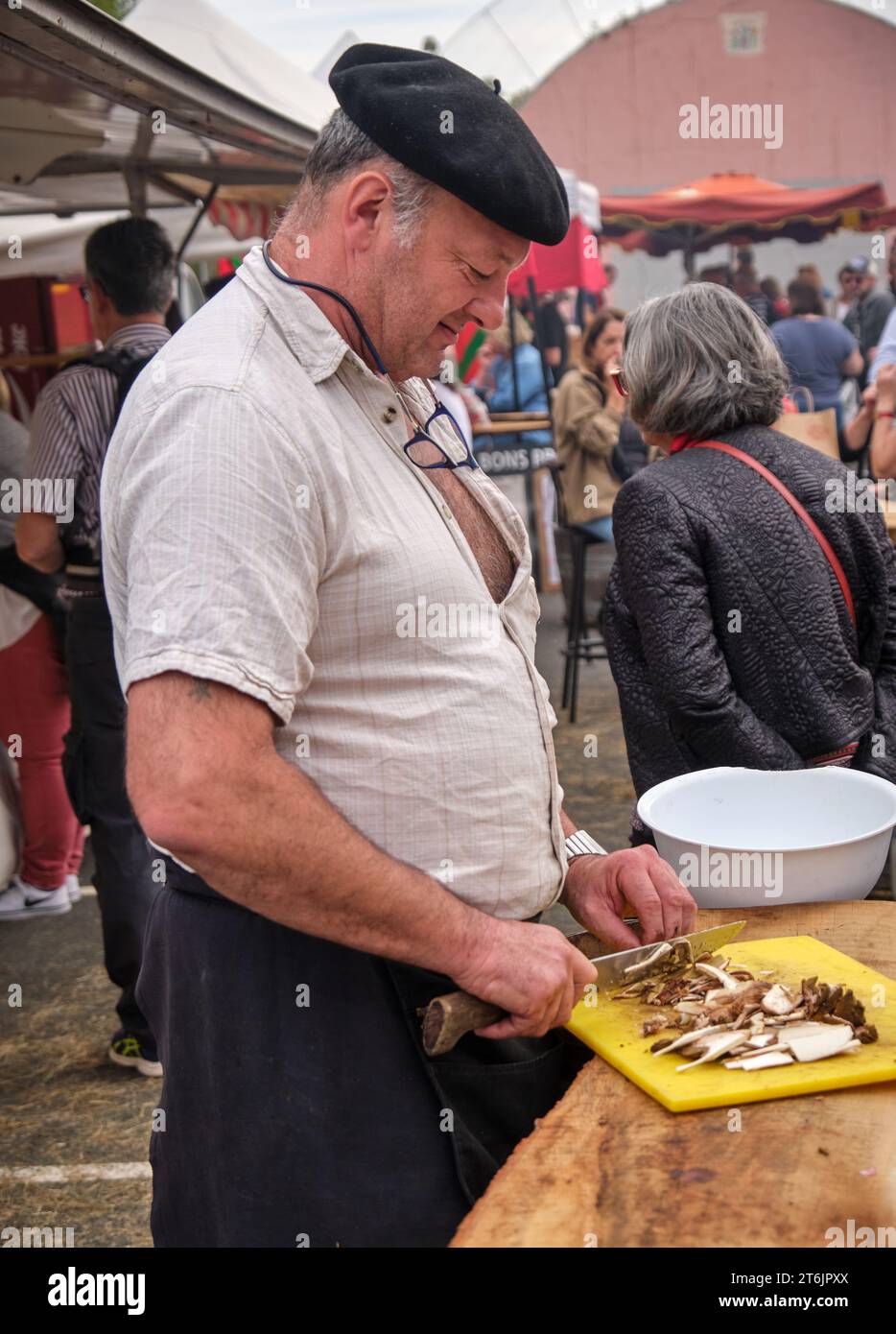 Baskenmütze schneidet Ceps auf dem Markt während des Pfefferfestivals in Espelette, Frankreich Stockfoto