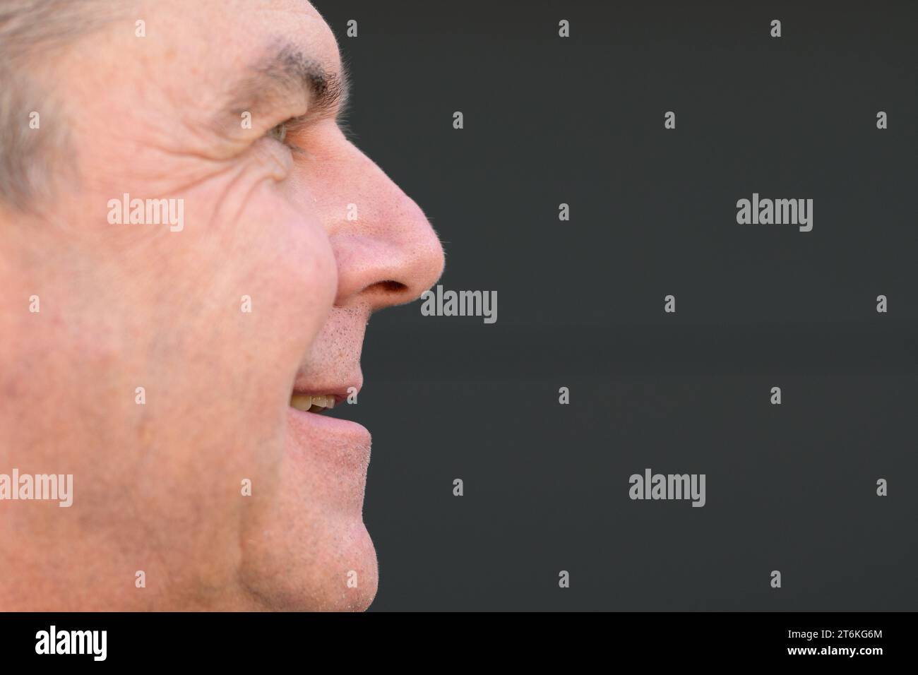 Extremes Nahbild eines Mannes mittleren Alters mit offenem Mund ohne Zahnersatz vor einer schwarzen Wand Stockfoto