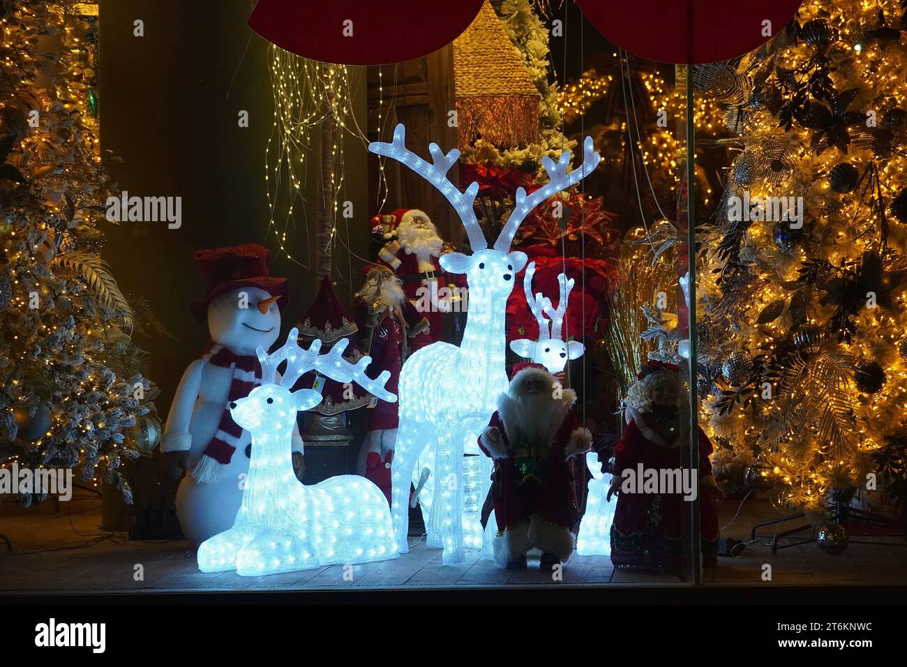 Leuchtende Hirsche, Schneemänner und Weihnachtsbäume in einem Weihnachtsdekorationsgeschäft Stockfoto