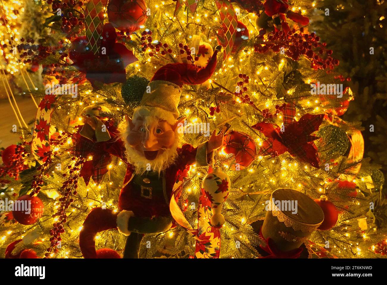 Festliche Weihnachts-Elfe auf einem beleuchteten Baum Stockfoto