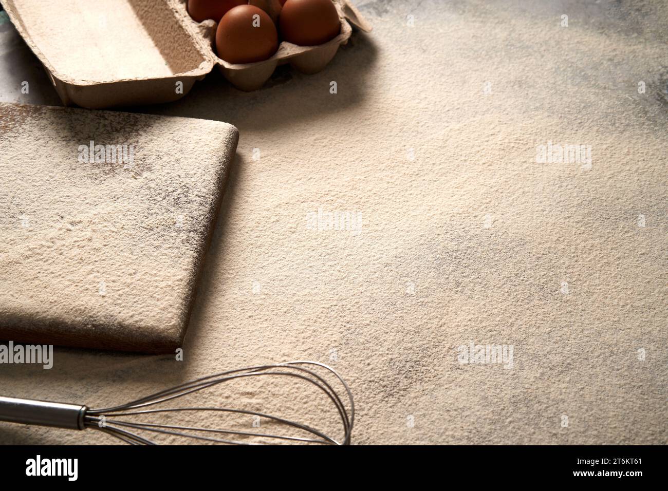 Backhintergrund mit Mehl, Schneidebrett, Eier auf einem Tisch, Hochwinkel-Fotoansicht. Stockfoto