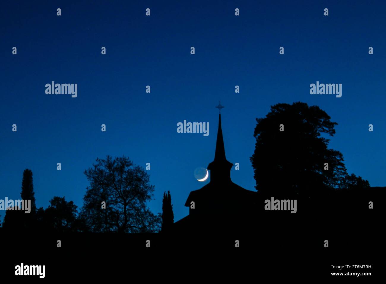 Kapelle und Bäume unter der Mondsichel in Valeyres-sous-Rances, Schweiz Stockfoto