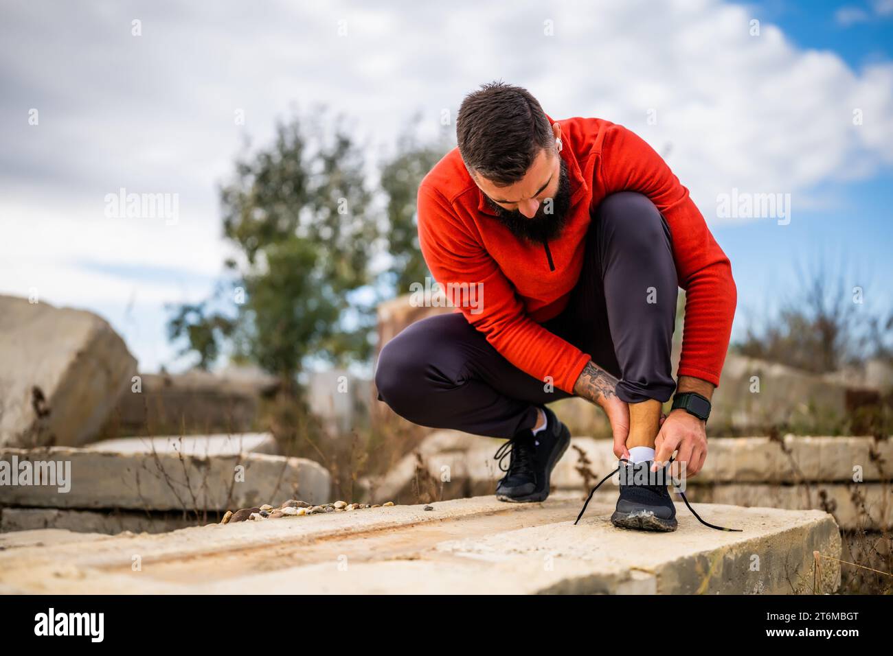 Der junge Mann hat Schmerzen im Knöchel, während er im Freien trainiert. Stockfoto