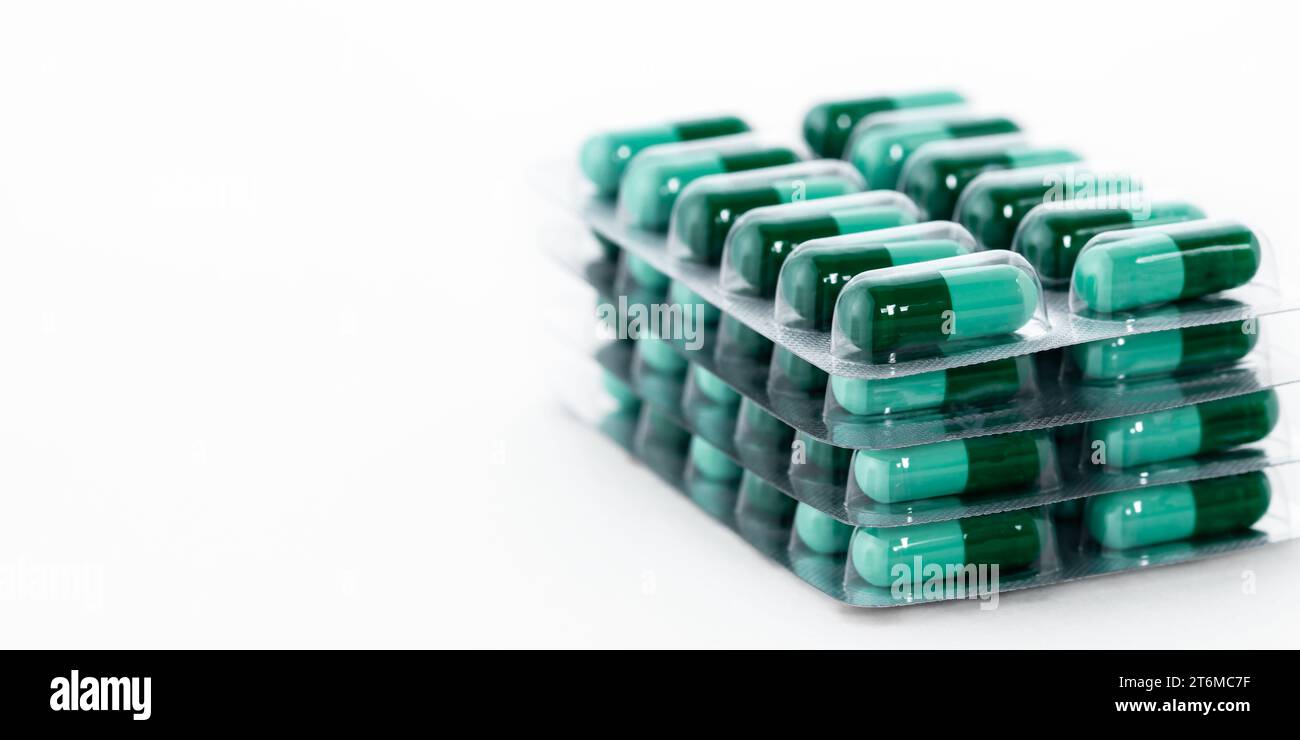 Grüne Pillen in Plastikverpackung. Globales Konzept der Gesundheits- und Pharmaindustrie. Stockfoto