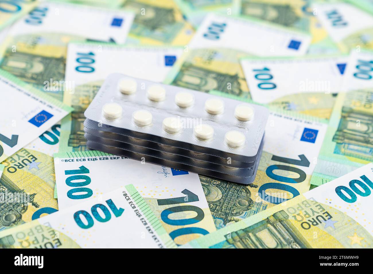 Blisterstapel mit weißen Pillen auf Euro-Banknoten als Hintergrund, Konzept der Krankenversicherung. Hochwertige Fotos Stockfoto