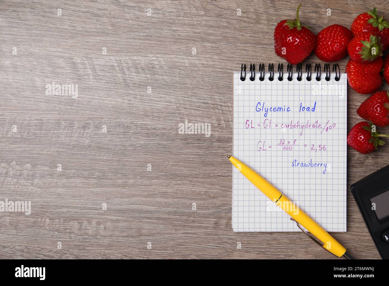 Notizbuch mit berechneter glykämischer Belastung für Erdbeeren und frische Beeren auf Holztisch, flach gelegt. Leerzeichen für Text Stockfoto