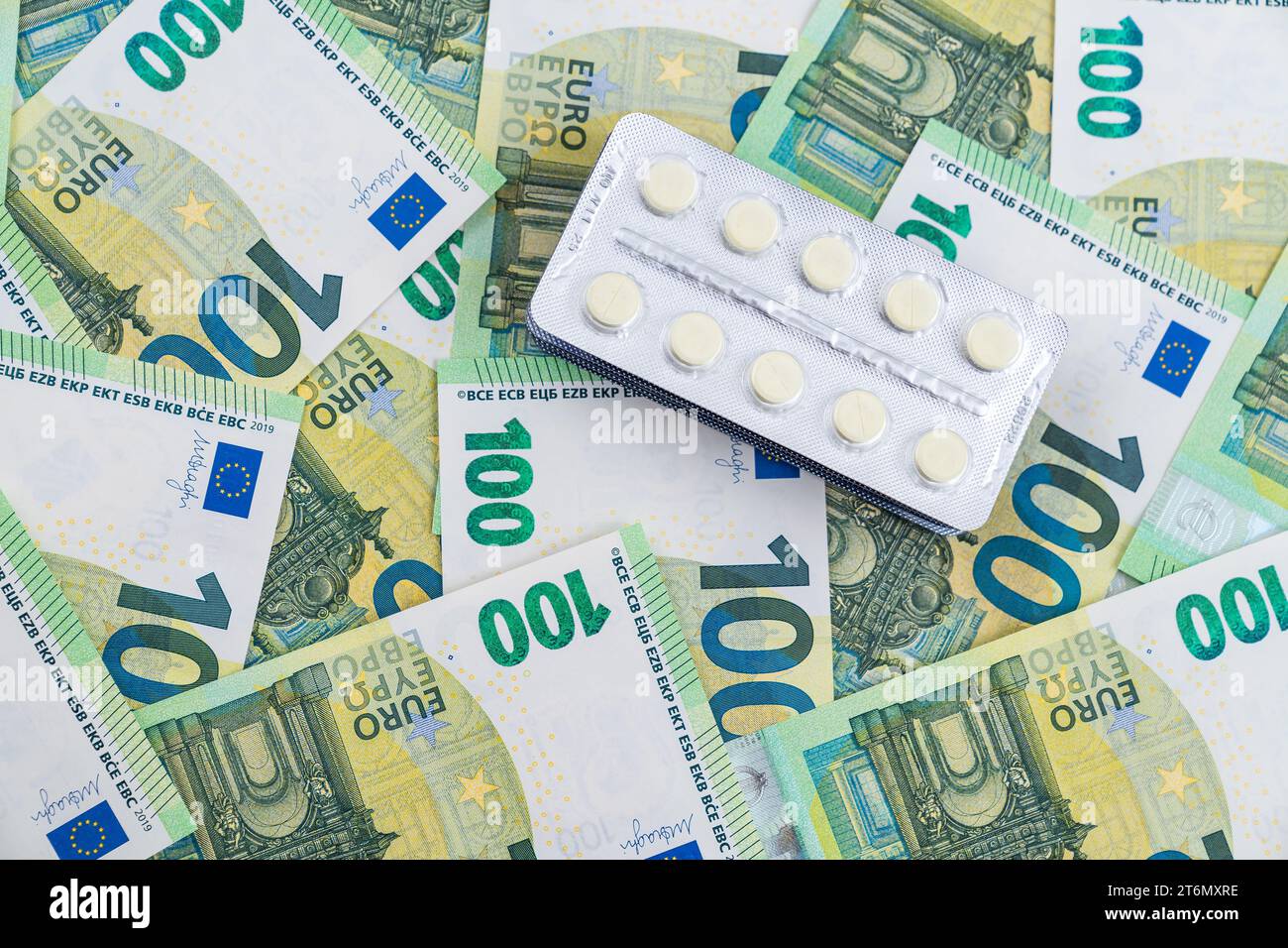 Blick von oben auf Blasen mit Pillen auf Eurorechnungen als Hintergrund. Hohe Kosten für medizinische Versorgung Konzept. Hochwertige Fotos Stockfoto