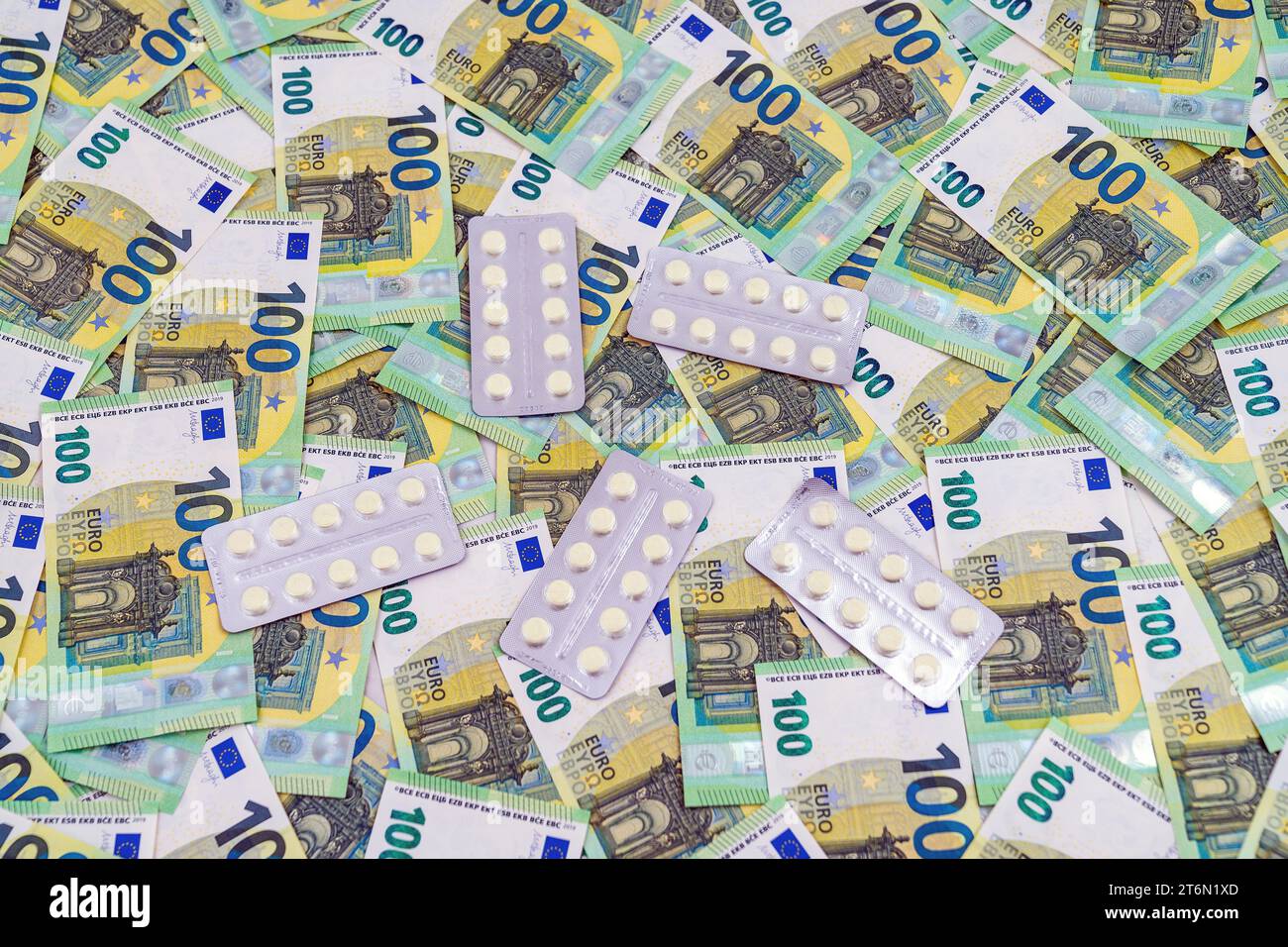 Blasen mit Pillen, die zufällig auf Euro-Rechnungen platziert wurden, als Hintergrund, teures Medizinkonzept. Hochwertige Fotos Stockfoto