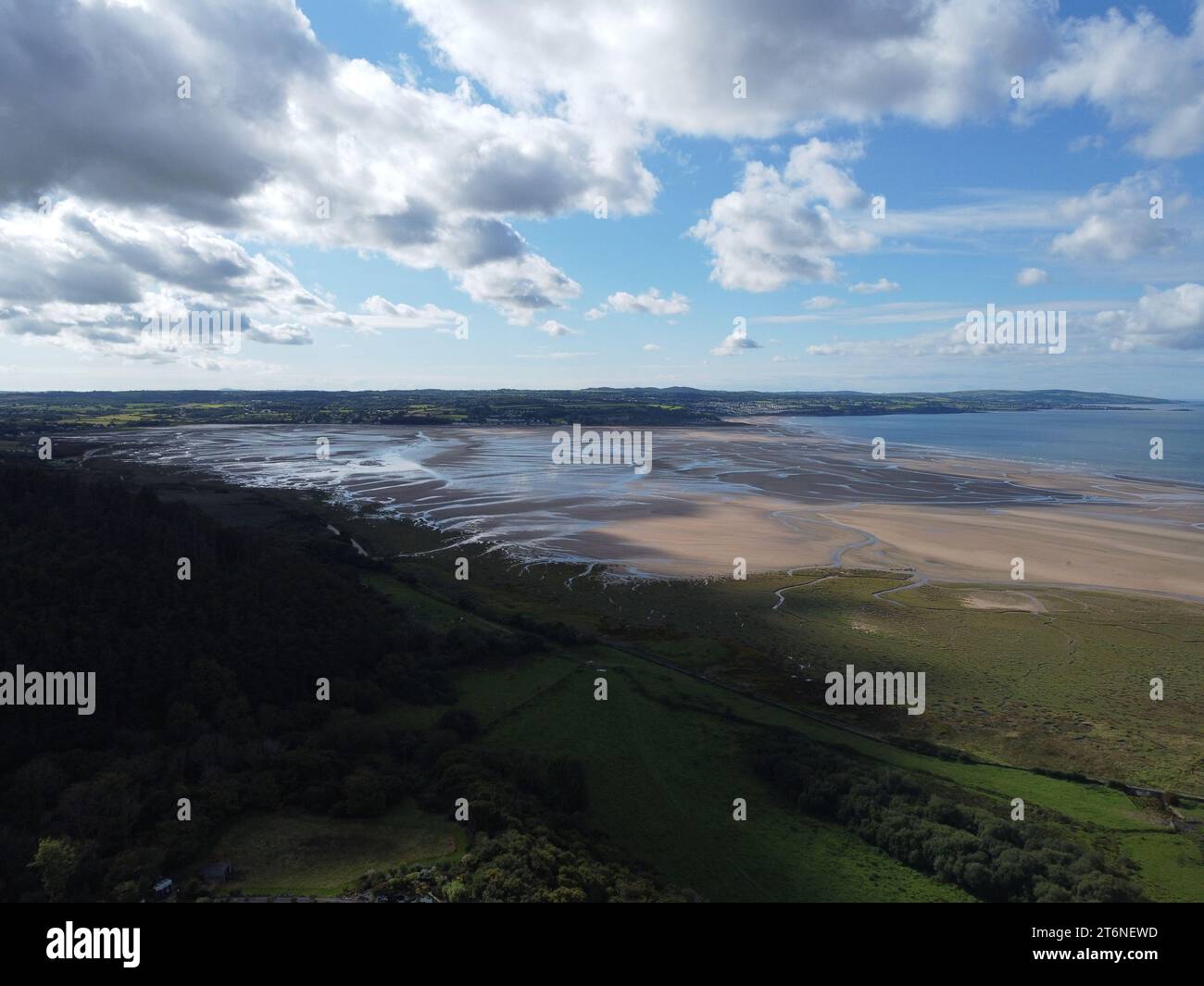 Irische See über den atemberaubenden Feldern an der Red Wharf Bay in Anglesey, Wales, Großbritannien mit dem Dorf Benllech im Hintergrund Stockfoto