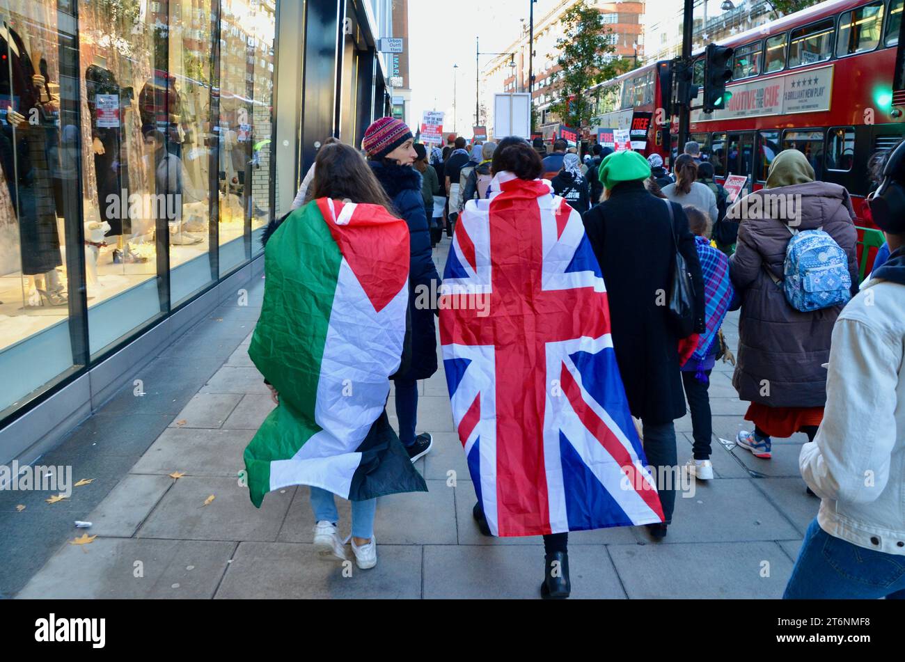 palästinensische und britische Fahnen, die von Frauen in der oxford Street getragen werden; Szenen aus der Massendemonstration gegen den Krieg pro Waffenstillstand in Zentral-london, die einen Waffenstillstand in palästina israel gaza 11. november 2023 forderte Stockfoto