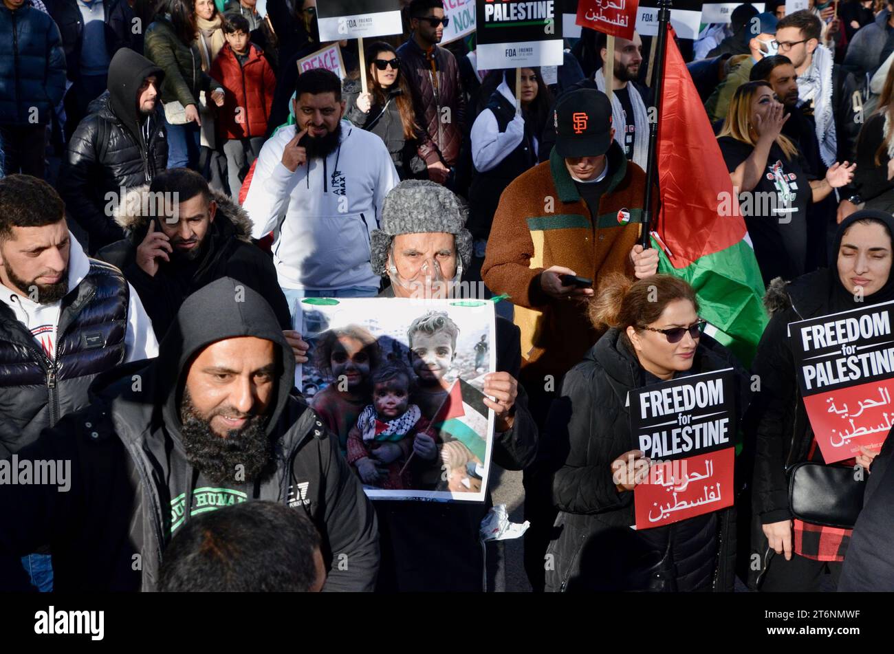 Älterer muslimischer Mann mit Sauerstoffmaske trägt ein Foto von bombardierten palästinensischen Kindern; Szenen aus der Massendemonstration gegen den Krieg pro Waffenstillstand in Zentral-london, die einen Waffenstillstand in palästina israel gaza 11. november 2023 forderte Stockfoto