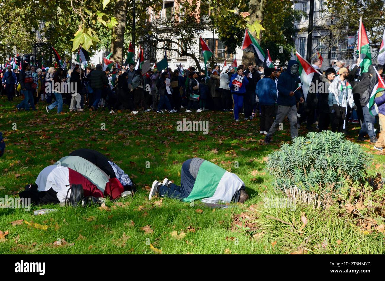 Eine Familie bricht zum Gebet; Szenen aus der Anti-Krieg-Demonstration im Zentrum londons, die einen Waffenstillstand in palästina israel gaza am 11. november 2023 forderte Stockfoto