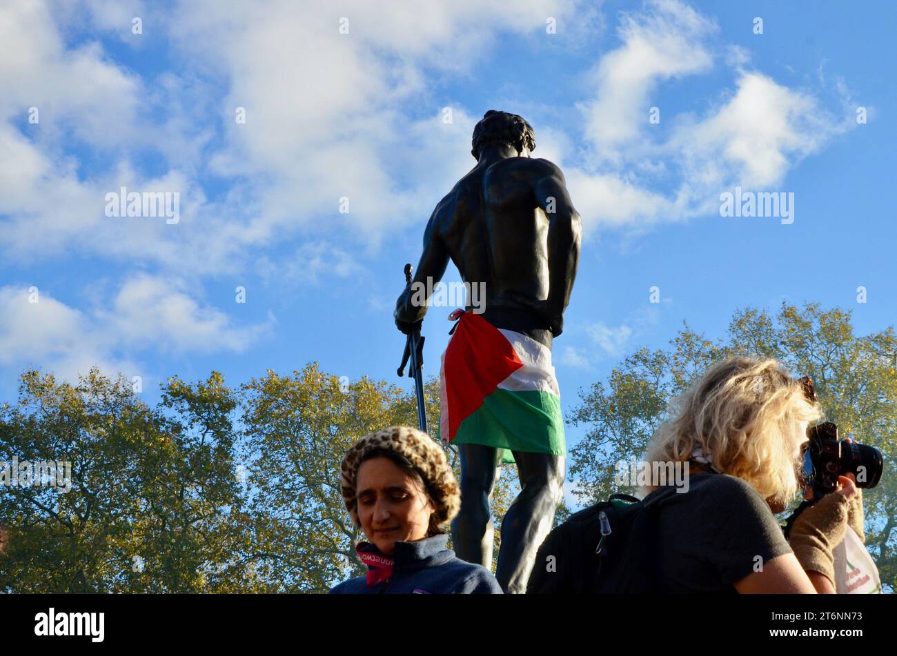 Mahnmal des Maschinengewehrkorps mit palästinensischem Flaggenrock; Szenen aus der Massendemonstration gegen den Krieg pro Waffenstillstand in Zentral-london, die einen Waffenstillstand in palästina, israel, gaza, 11. november 2023 forderte Stockfoto