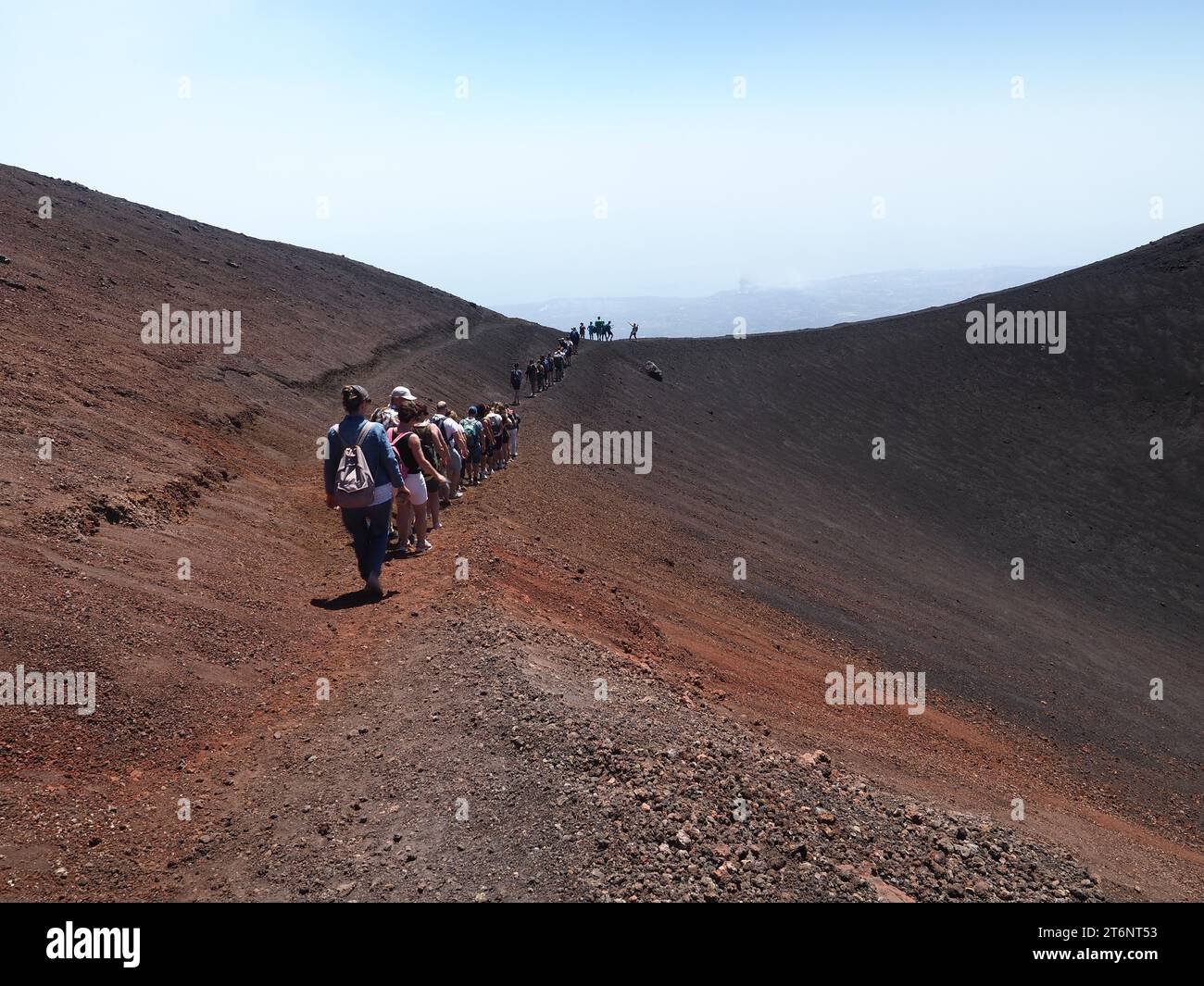 Eine Schlange von Touristen, die in einem vulkanischen Berg (Ätna), Sizilien Italien, unterwegs sind Stockfoto