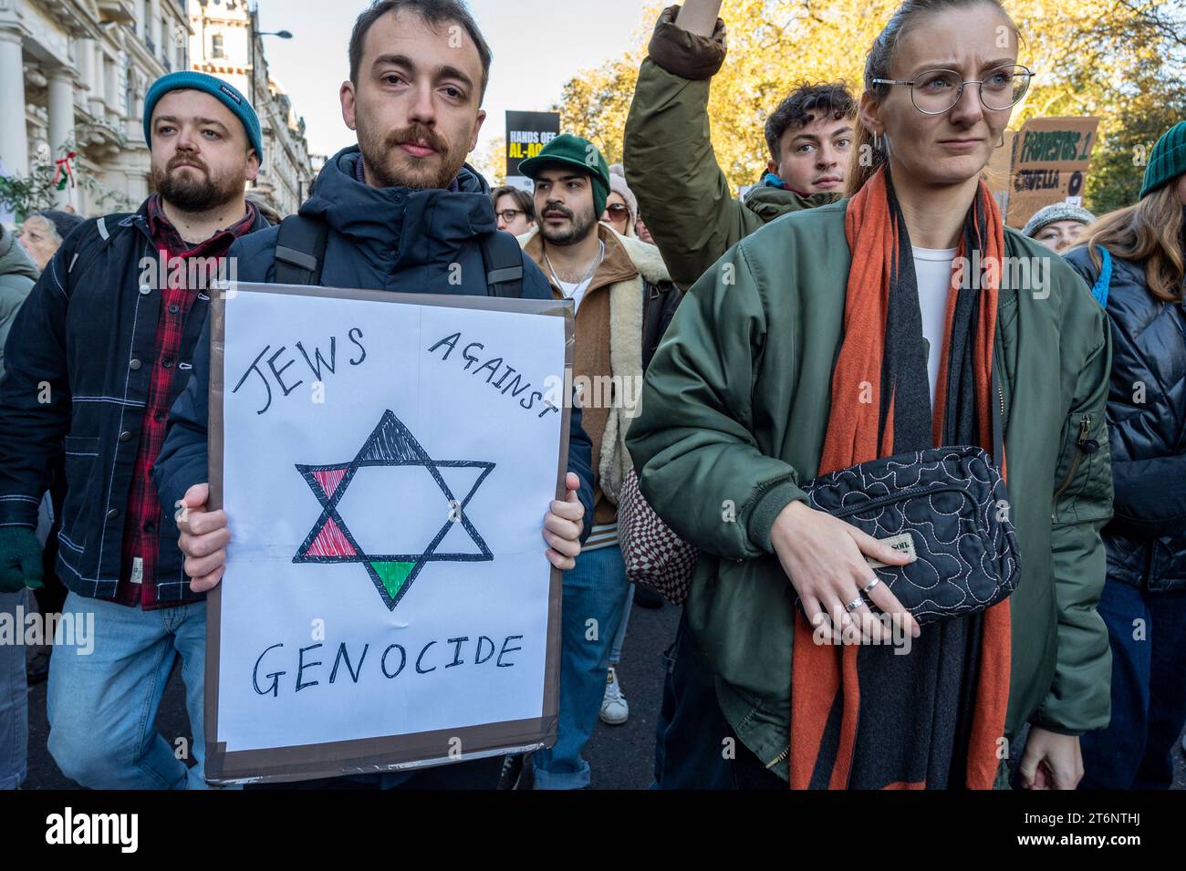Protest gegen die Bombardierung von Gaza. Ein junger Mann mit einem Plakat "Juden gegen Völkermord" mit einem Davidstern in palästinensischen Farben. 11. November 2023 Stockfoto