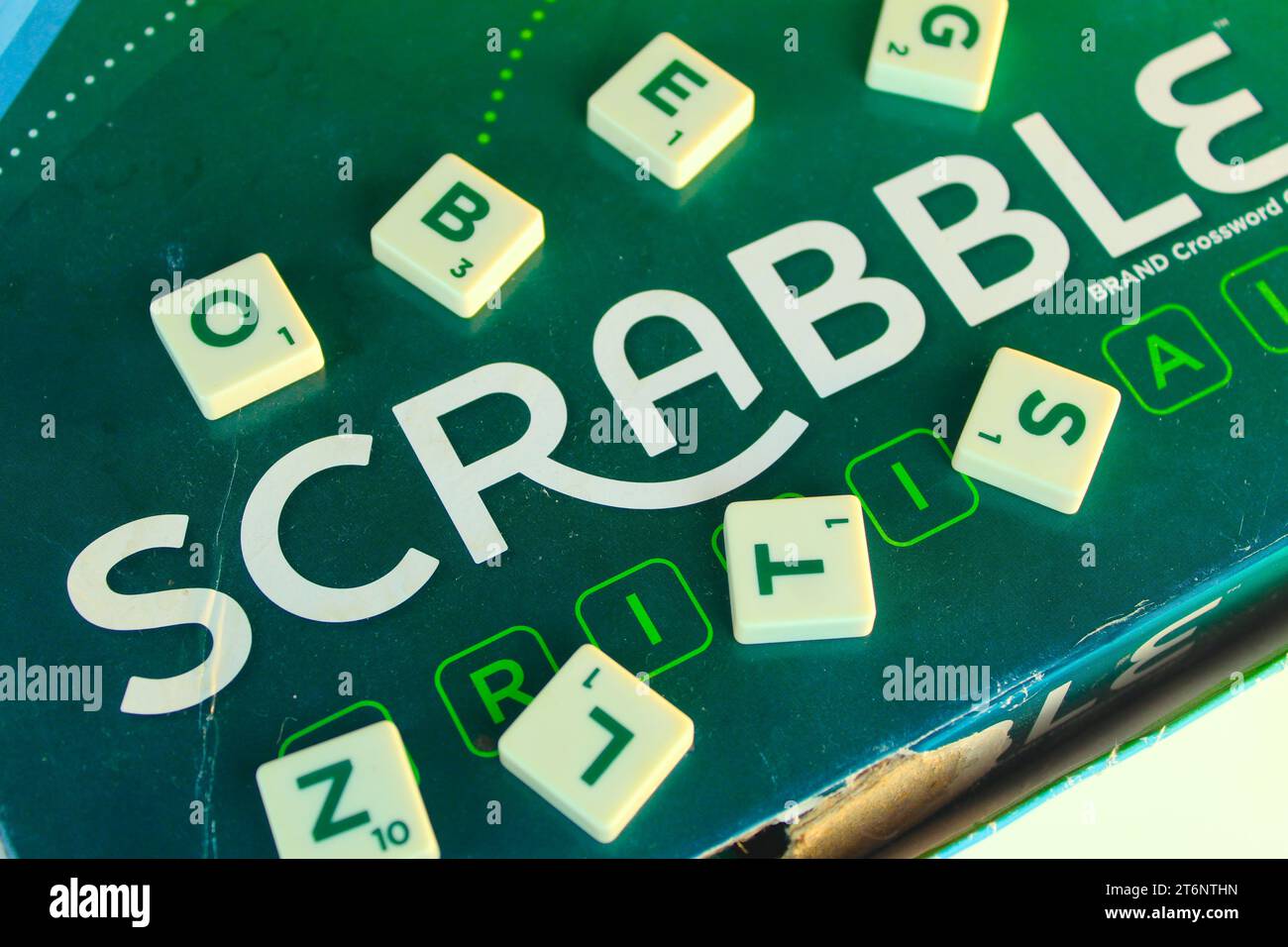 Ein Foto der Spielbox „Scrabble“ auf dem grünen Brett. Stockfoto