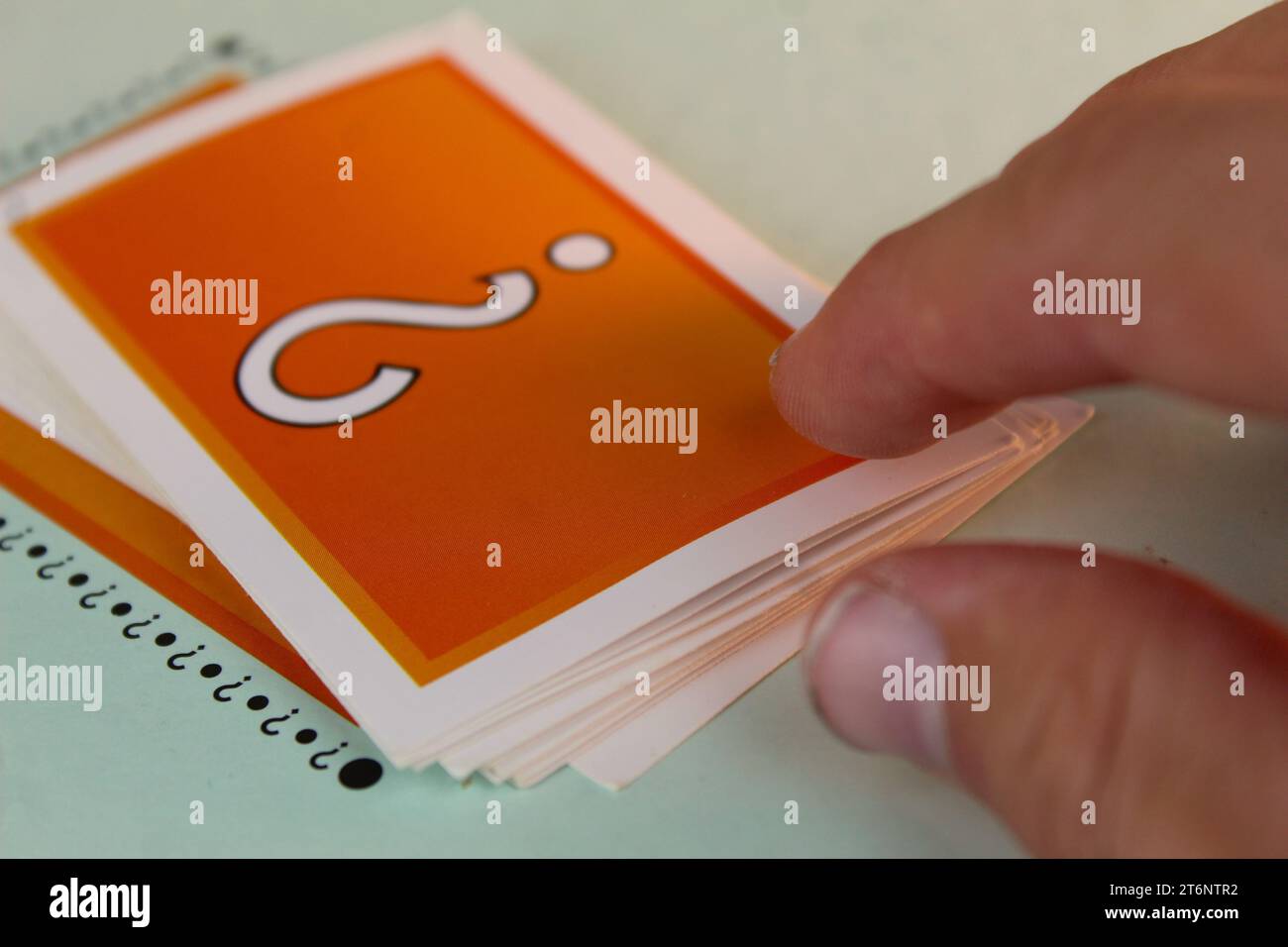 Ein Foto von jemandem, der im Rahmen des Monopoly-Brettspiels auf eine orange Glückskarte zugreift. Stockfoto