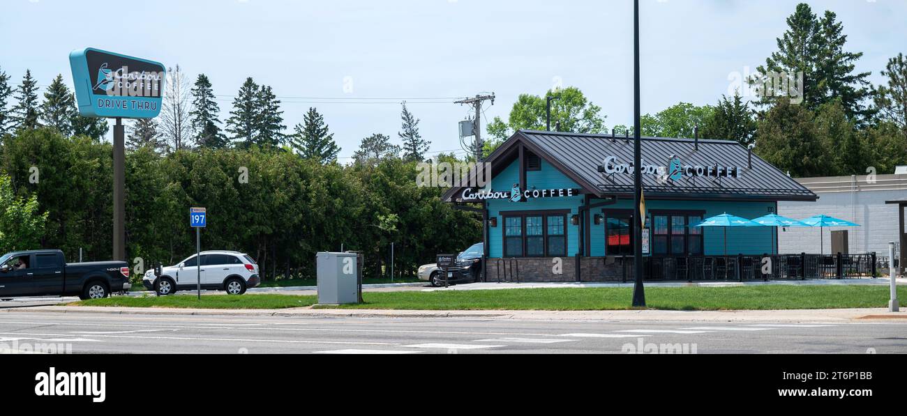 BEMIDJI, MN - 3. JUN 2023: Caribou Coffee Building und Fahrt durch Fahrzeuge auf einem Eckplatz. Stockfoto