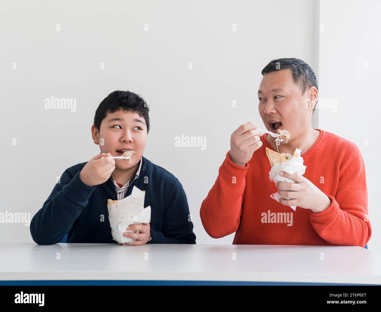 Asiatischer Vater Sohn isst Fast Food Stockfoto