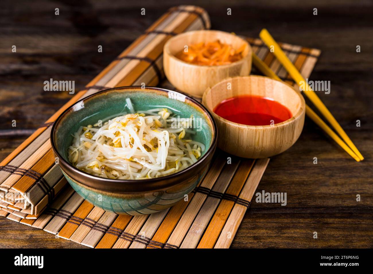 Schüsseln keimte Bohnen rote Chilisauce mit Stäbchen Tischset Tisch Stockfoto